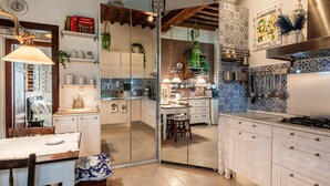 Una cucina con zona pranzo, mobili in legno, un fornello e un lampadario.