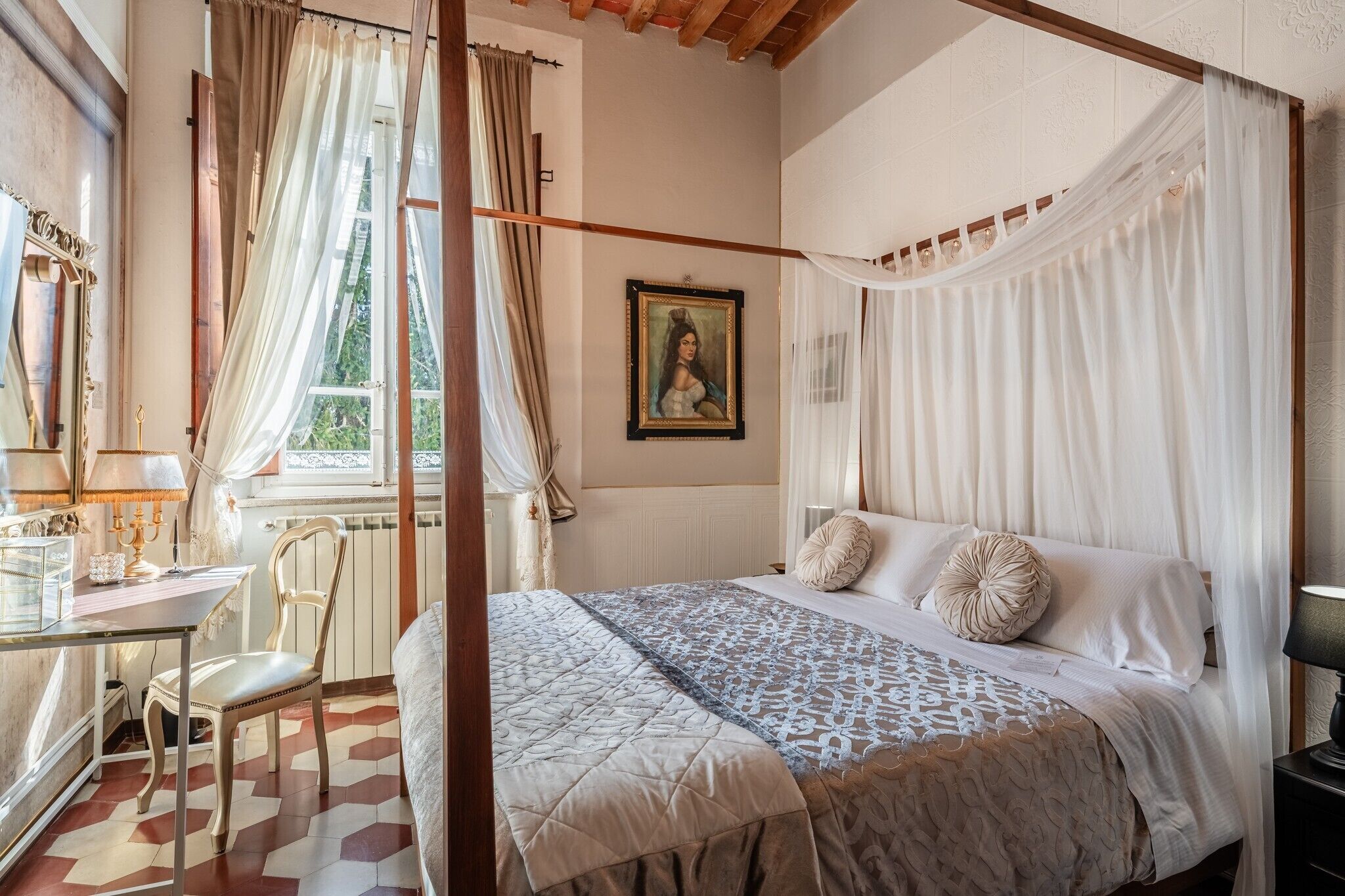 Une chambre à coucher avec un lit à baldaquin, un bureau avec une lampe, une chaise et une fenêtre avec des rideaux.
