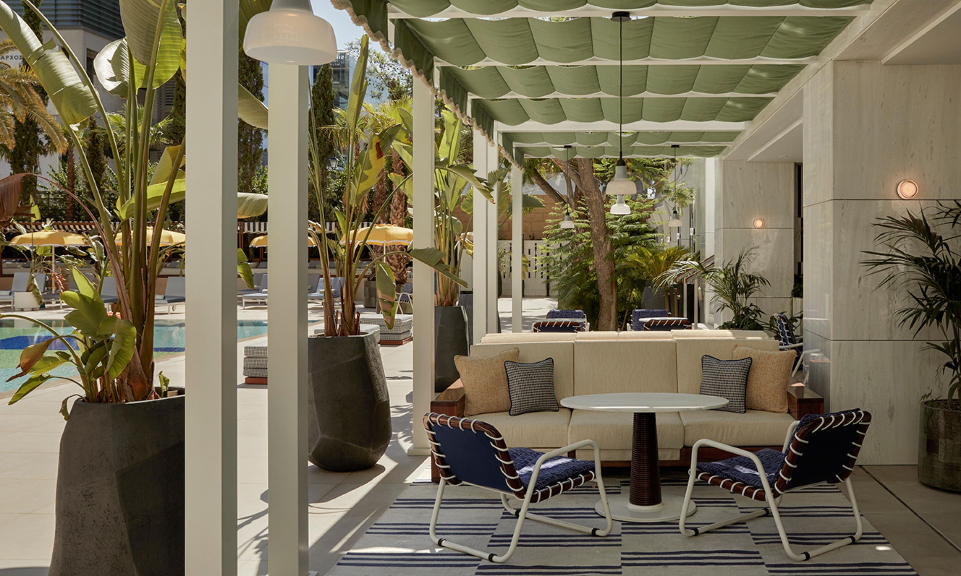 An outdoor seating area with a pool, lounge chairs, and a sofa.