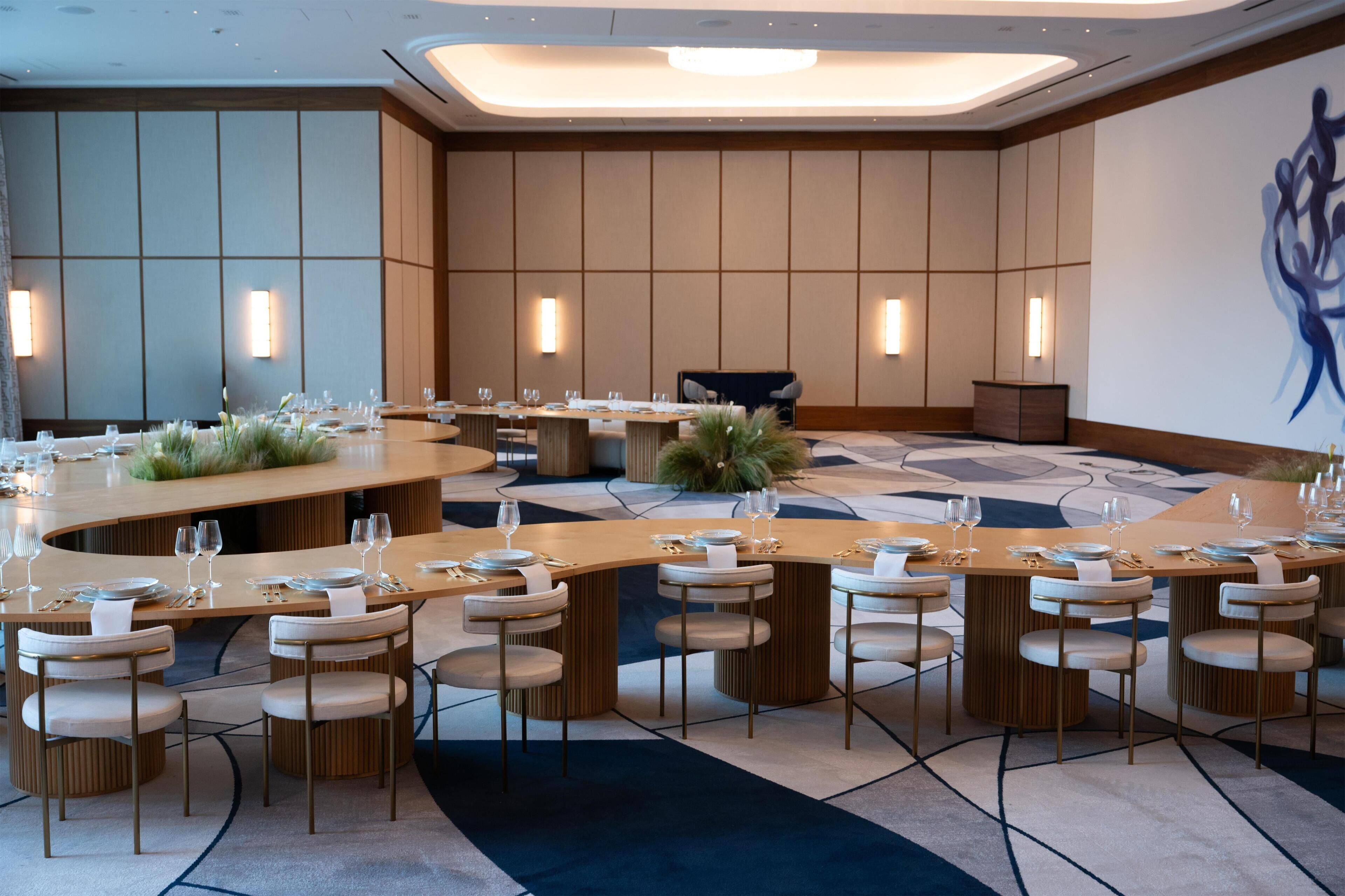 A modern dining area with round tables, chairs, and a central bar.
