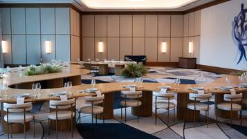 A modern dining area with round tables, chairs, and a central bar.