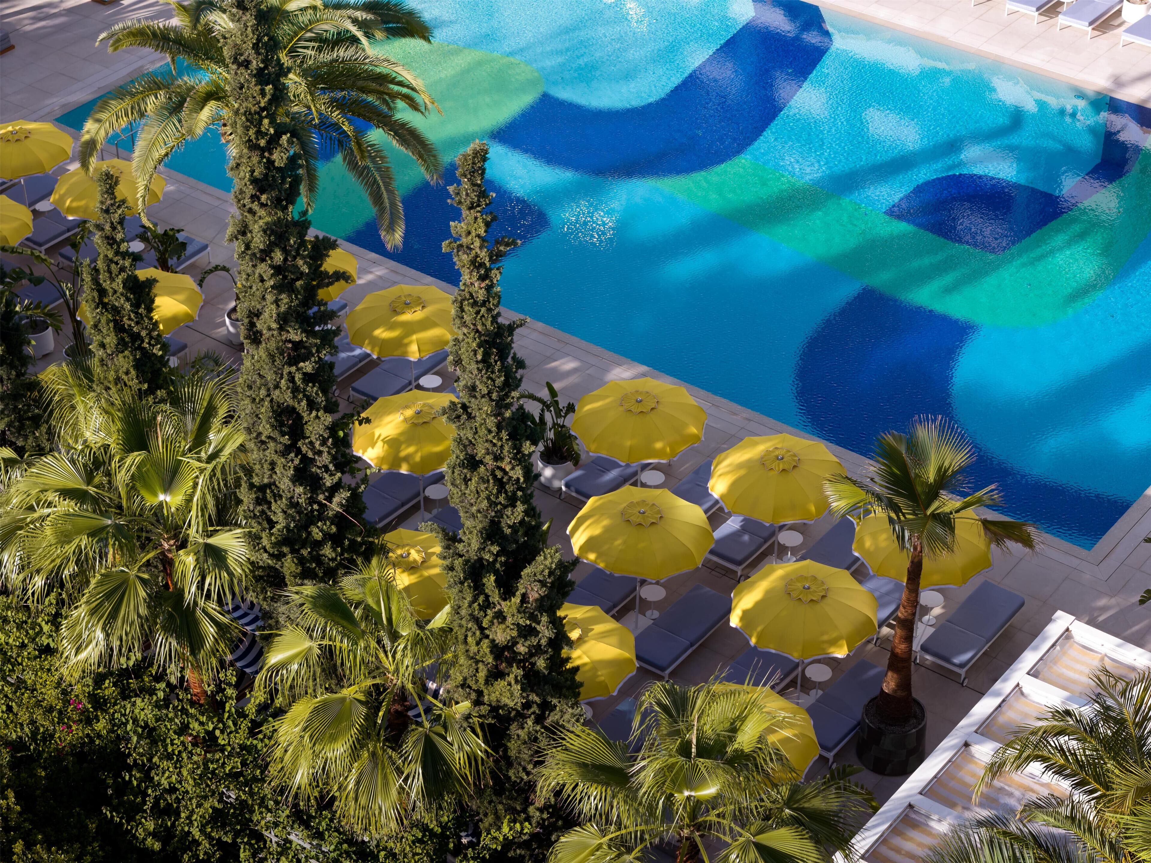 A pool area with yellow umbrellas and lounge chairs.