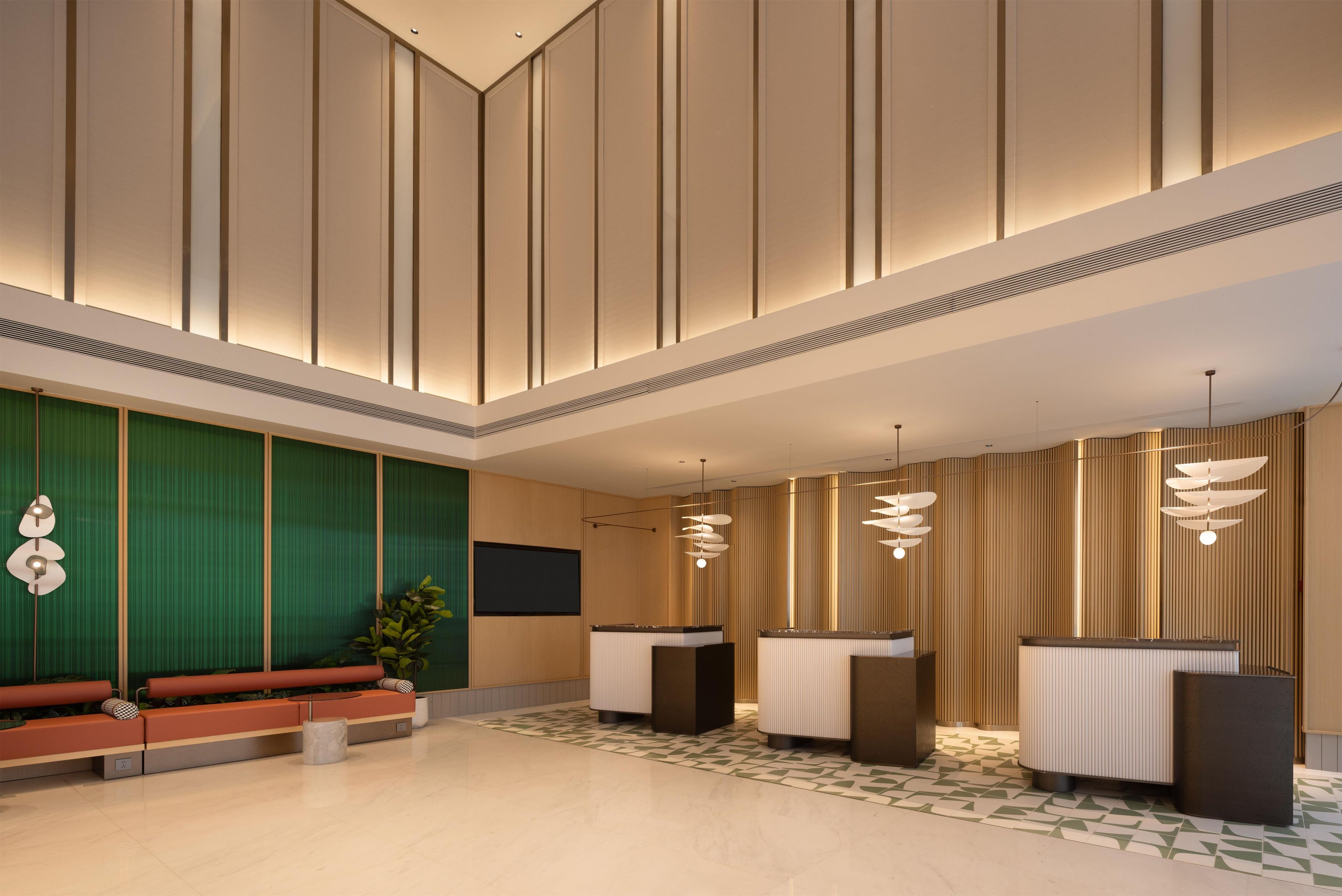 A modern lobby with a reception desk, seating area, and decorative lighting.