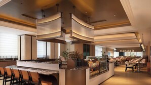 A modern restaurant with a central bar, seating area, and a view of the dining space. - Hilton Garden Inn Zhengzhou Airport Aerotropolis (Zhengzhou)