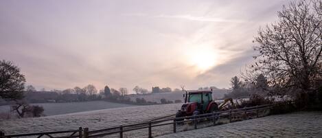 Een bevroren landschap met een tractor nabij een houten poort.