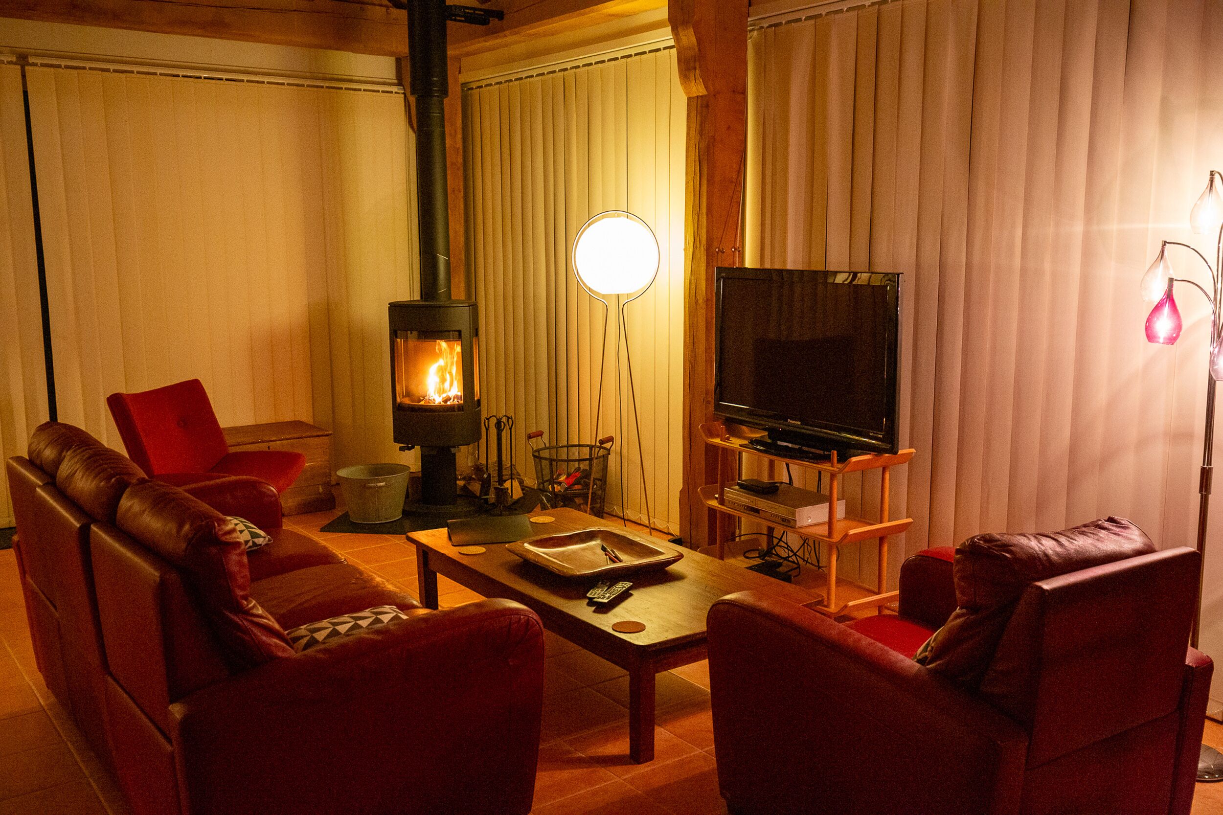 A cozy living room with a fireplace, leather sofas, a coffee table, and a television.