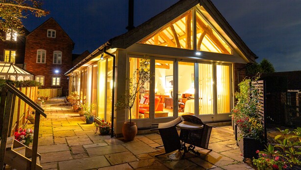 A cozy, well-lit patio area with a wooden deck, outdoor seating, and potted plants. - Nature's Lodge (Kidderminster)