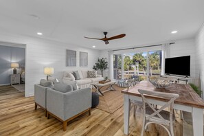 A modern living room with a sofa, coffee table, and dining table.