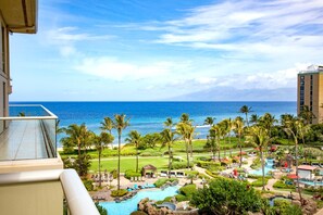 Un resort con piscina, palmeras y vistas al océano.