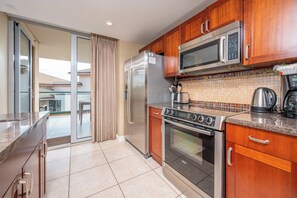 A modern kitchen with wooden cabinets, a stainless steel refrigerator, a Bosch oven, and a microwave. - Honua Kai | Ocean View 7 BR, Sleeps 20 | Car Incl. w/ 6+ Nights | HKH ML-1949 by KBM (Lahaina)