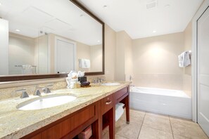 Un baño moderno con dos lavamanos, un espejo grande y una bañera.