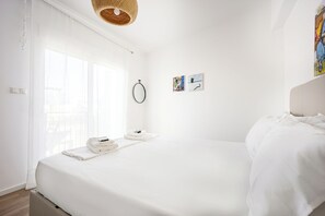A modern hotel room with a large bed, a hanging light fixture, and artwork on the wall. - Cozy 2BR Near Metro Acropolis View (Athens)