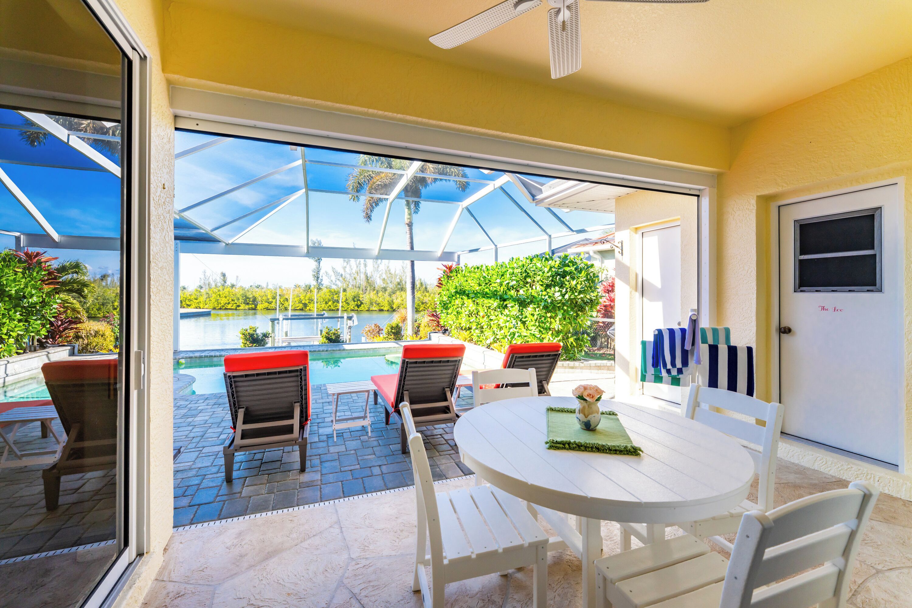 A patio with a pool, outdoor seating, and a glass door leading to a pool area.