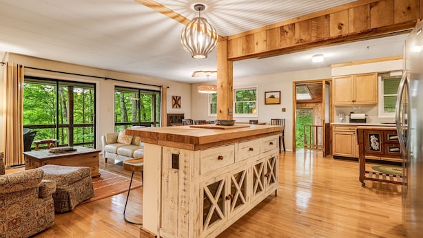 A spacious kitchen with wooden cabinets, a large island, and a view of the outdoors.