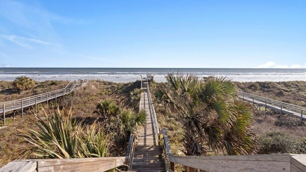 A wooden boardwalk leading to the beach with palm trees and a clear sky. - Pelican Inlet C119 - Near Beach Pool & Tennis (St. Augustine)