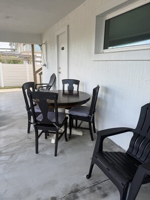 A covered patio area with a round table and four chairs. - The White House on Flagler Beach - Unit 11 (Flagler Beach)