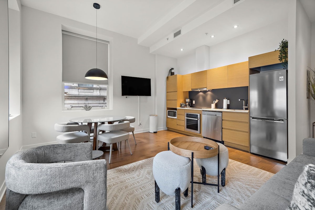 A modern kitchen with a large refrigerator, wooden cabinets, and a built-in oven.