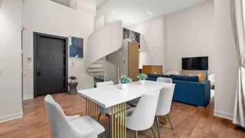Un appartement moderne comprenant un coin repas, un salon et un escalier.