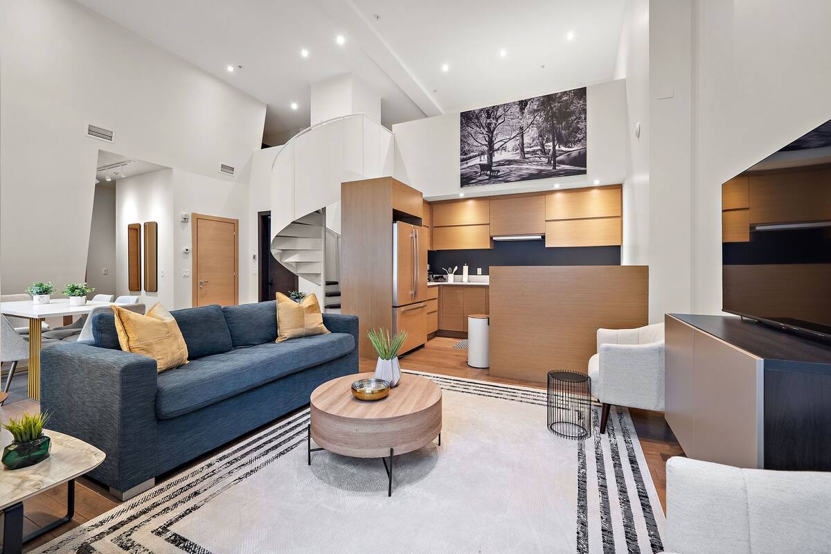 A modern living room with a sofa, coffee table, and a TV.