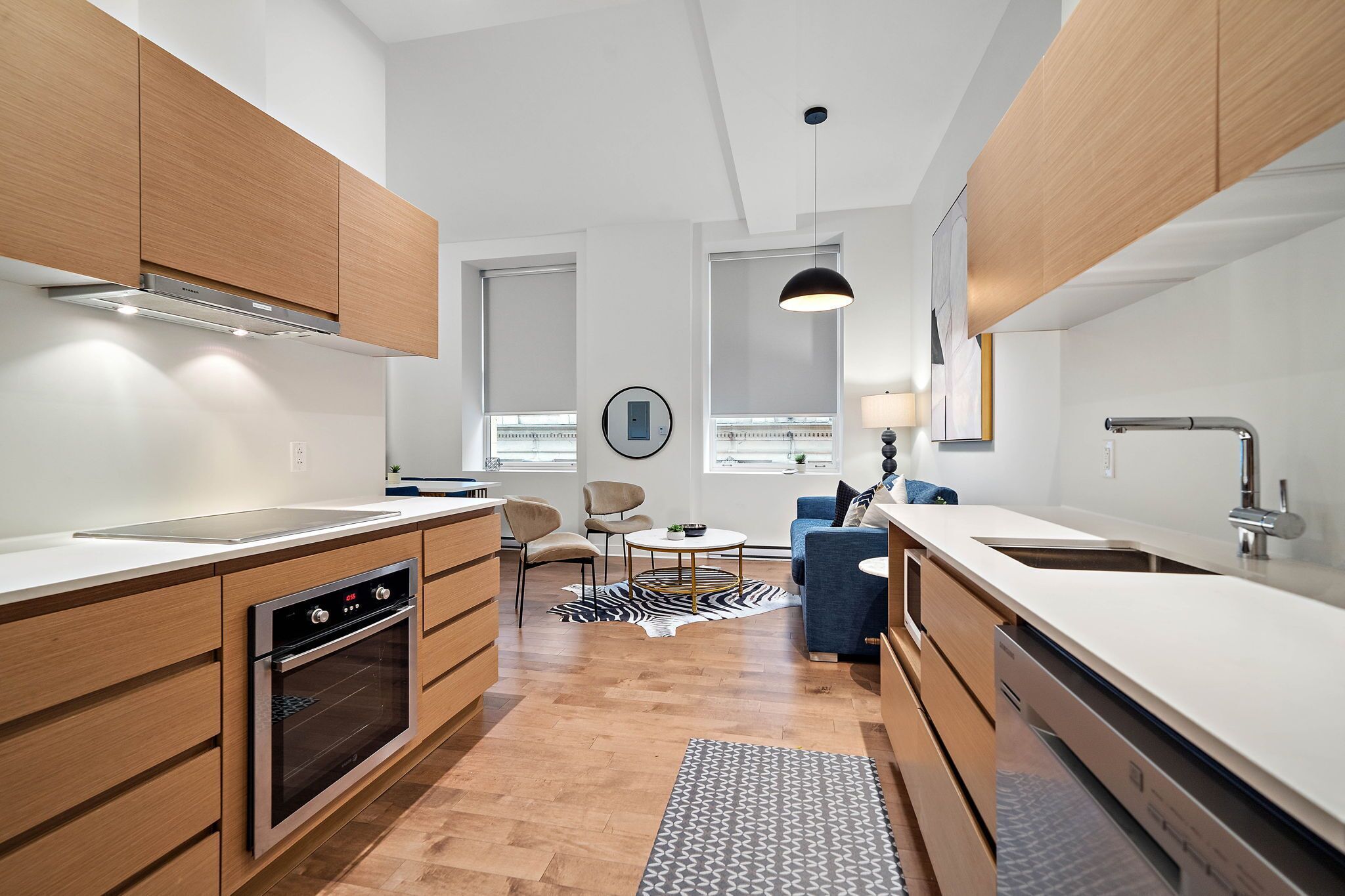 Una cucina moderna con mobili in legno, forno a incasso e un'isola grande con lavandino.