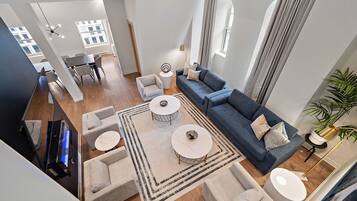 A modern living room with a sofa, two coffee tables, and a TV.