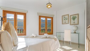 Ein Schlafzimmer mit einem Bett, zwei Fenstern, einem Schreibtisch und einem Globus.