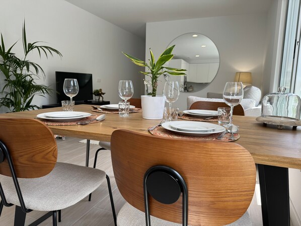 Un coin repas avec une table en bois, des chaises et une plante en pot.