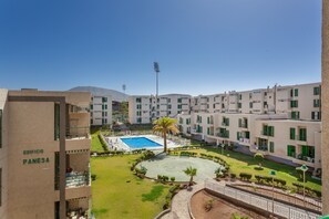 A hotel with multiple floors, a swimming pool, and a well-maintained courtyard.