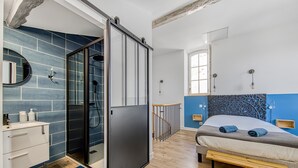 Une chambre à coucher moderne avec un lit, une salle de bain avec douche et un escalier.