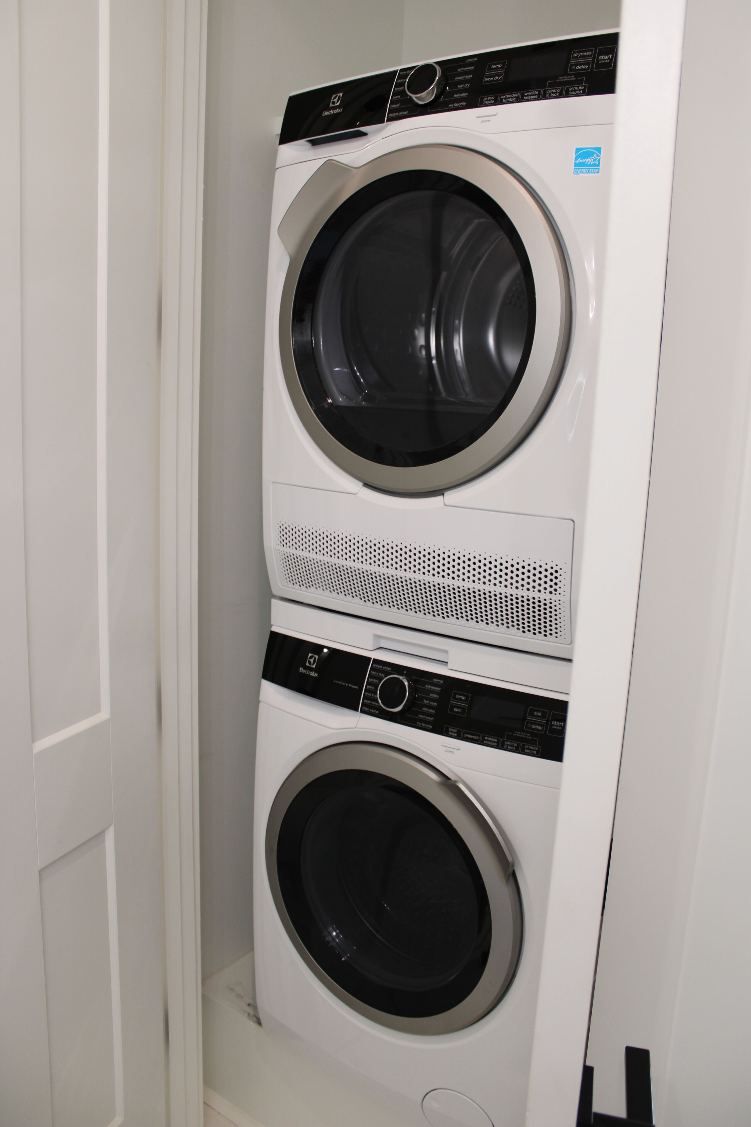 A stacked washer and dryer unit in a laundry room.