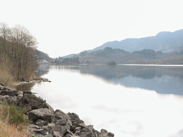 A calm lake with rocky shores and distant mountains. - Altair Lodge (Crieff)