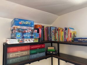 A bookshelf with various board games and books.