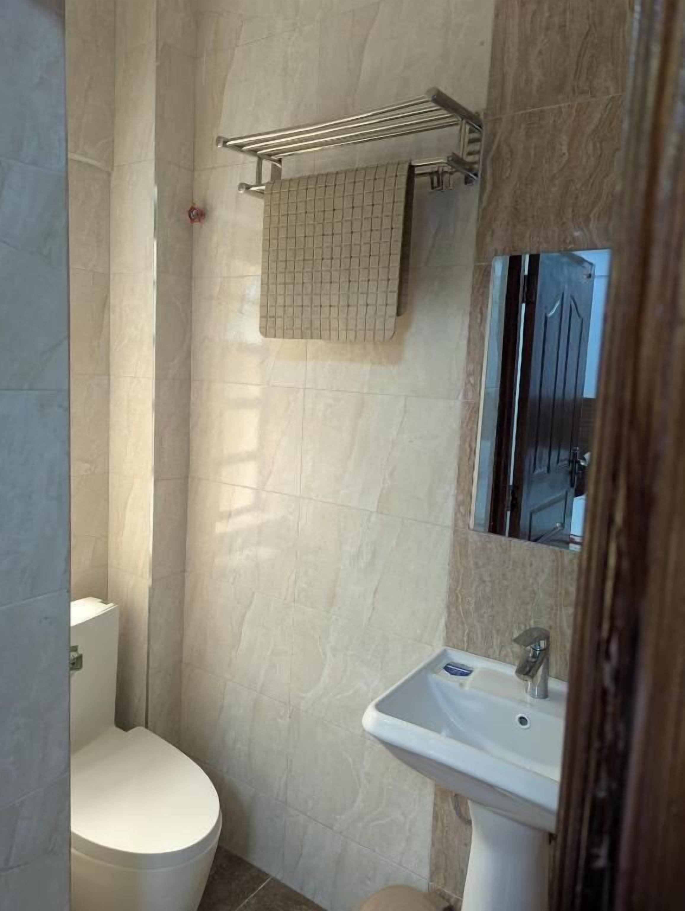 A small bathroom with a toilet, a sink, and a mirror.