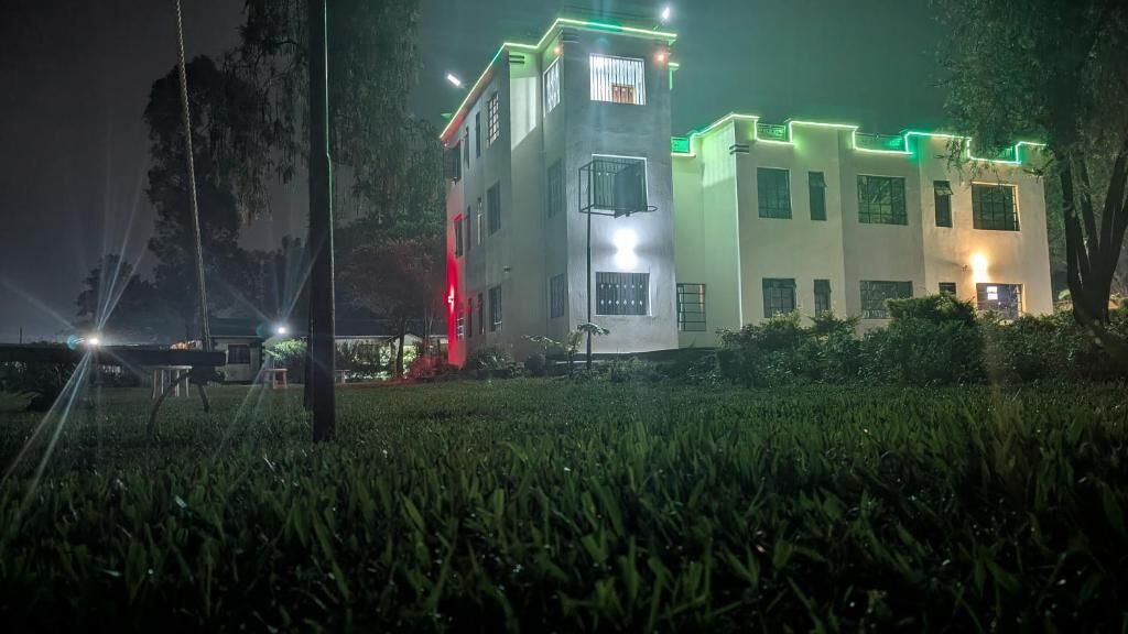 Un edificio de varios pisos con un diseño moderno, que presenta techo plano y grandes ventanales.