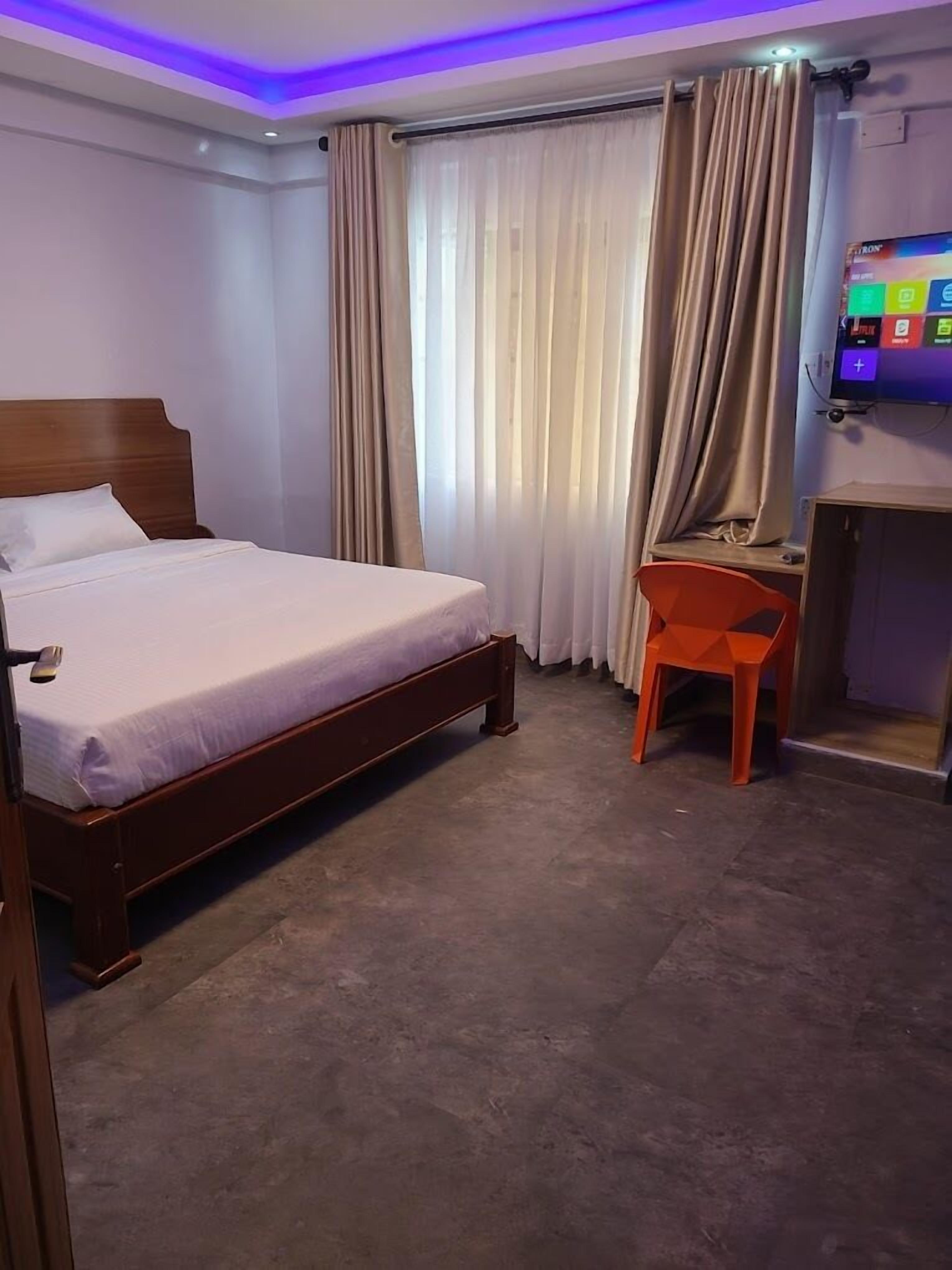 Una habitación de hotel con cama, escritorio y televisor.