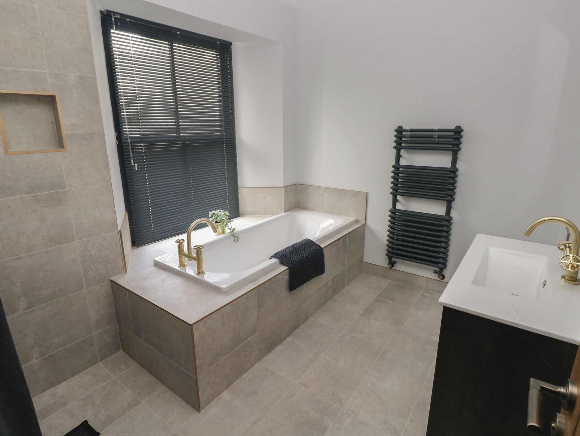 Une salle de bain moderne avec une baignoire sur pieds, un meuble-lavabo et un radiateur.
