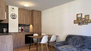Un espacio habitable compacto con kitchenette, zona de comedor y sala de estar.