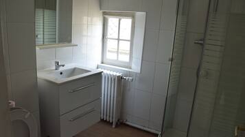 Een douche, handdoeken, zeep, toiletpapier