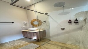 A modern bathroom with a glass-enclosed shower, a wooden vanity, and a round mirror. - Cómoda habitación Twin en Manga cerca al Centro (Cartagena)