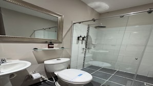 A modern bathroom with a toilet, sink, and glass-enclosed shower stall. - Habitación Múltiple Superior cerca a Getsemani (Cartagena)