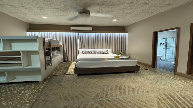 A modern hotel room with a large bed, a desk, and a ceiling fan. - Habitación Múltiple Superior cerca a Getsemani (Cartagena)