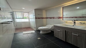 Un baño moderno con ducha, inodoro y tocador.