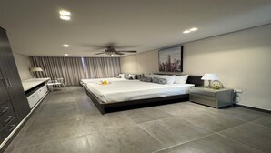 Una habitación de hotel moderna con una cama grande, un escritorio y una silla.