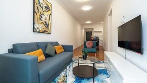 Un salon moderne avec un canapé, une table basse et des œuvres d’art accrochées au mur.