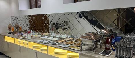 A buffet setup with various food items and utensils.
