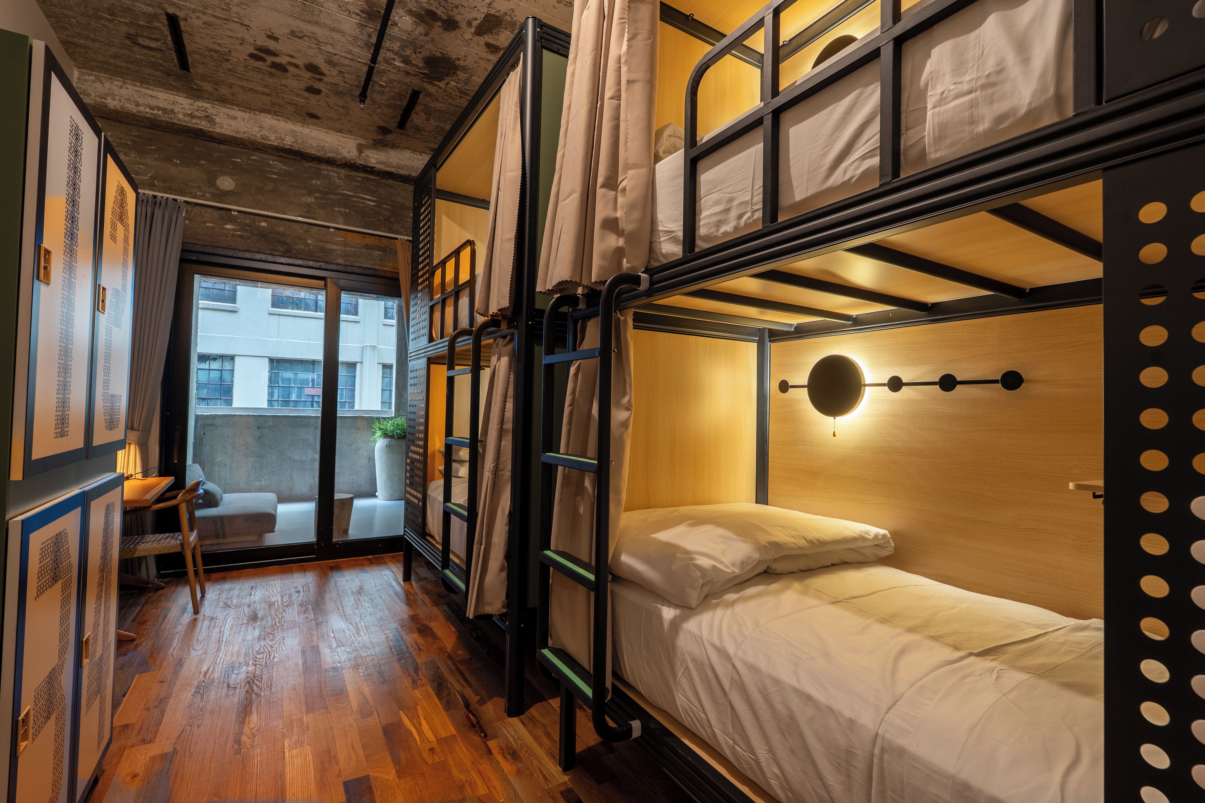 Une chambre avec un lit superposé, un plancher en bois, un bureau et une chaise.