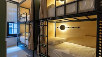 A bunk bed room with a window, a ladder, and a circular light fixture.