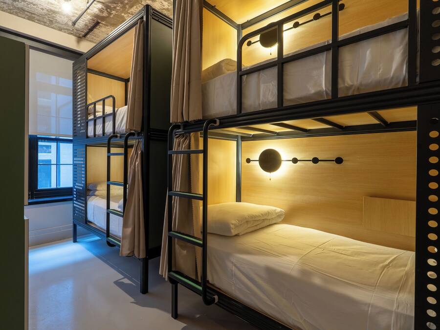 A bunk bed room with a window, a ladder, and a circular light fixture.