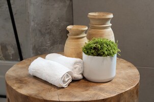 A round wooden table with a white towel and a potted plant.