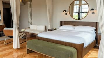 A modern bedroom with a wooden bed, a green bench, a white sofa, and a large mirror.